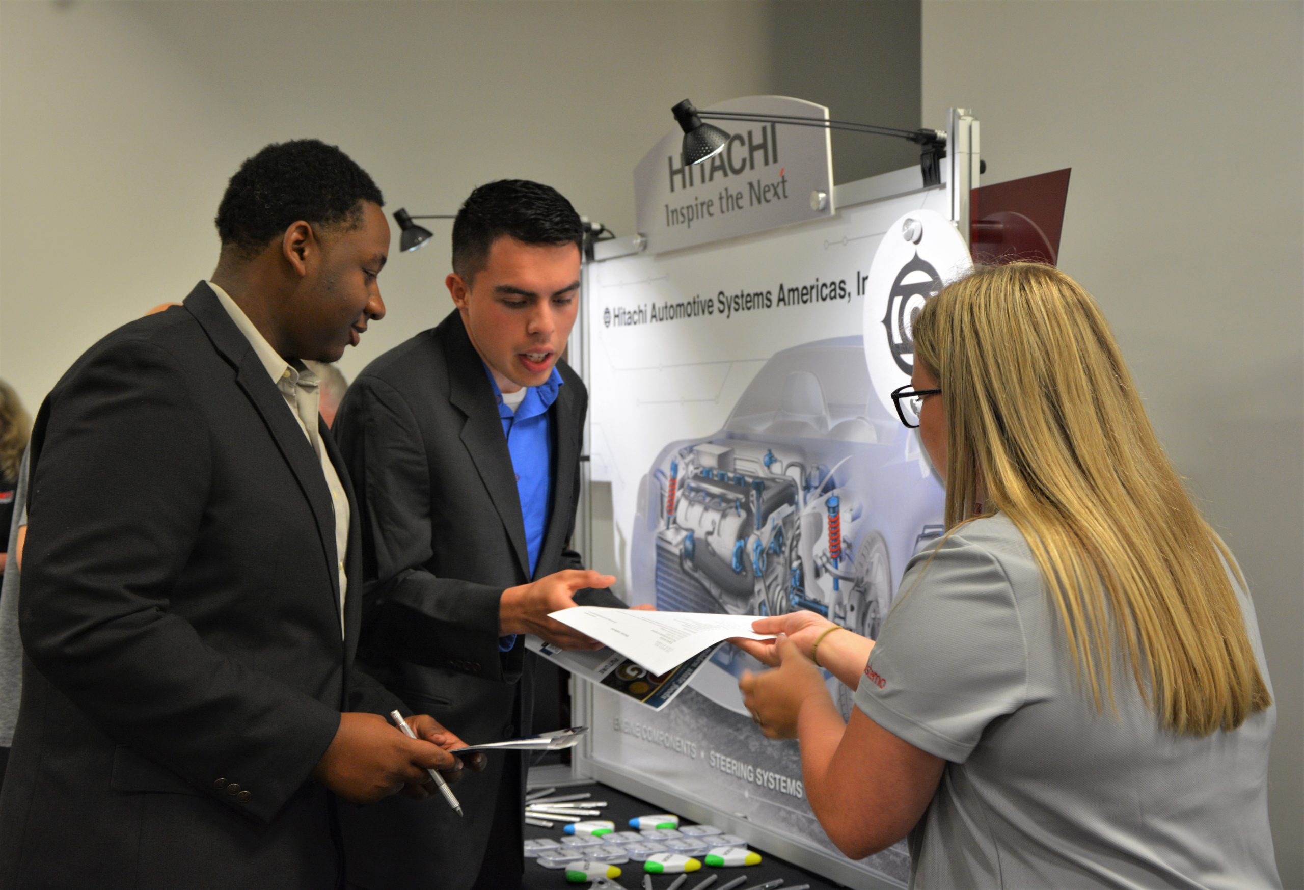 Attendees handing over resumes to potential employer