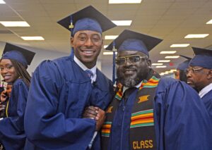 Two male graduates smiling and shaking hands