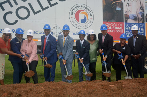 Dignitaries shoveling dirt while donning hardhats