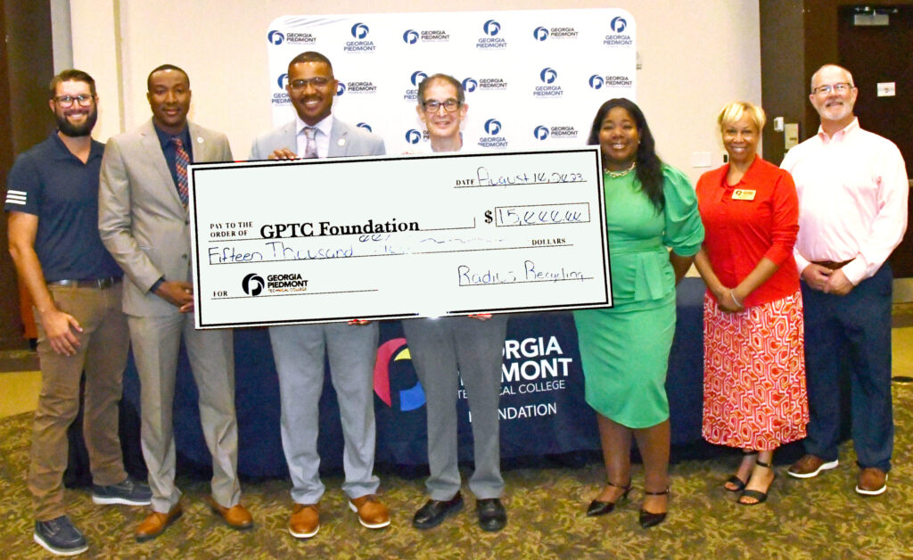 Officials with GPTC and Radius Recycling pose with the giant check.